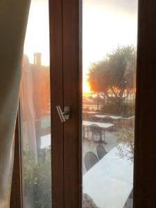eine Tür zu einer Terrasse mit Tisch und Stühlen in der Unterkunft El Boutique Hotel in Tyros