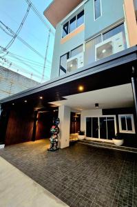 a building with a person standing in front of it at The Atlas hostel Muang Thong Thani in Thung Si Kan