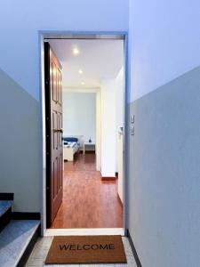 a hallway with an open door with a welcome mat at Casa Lungomare in Arenzano +16 photos