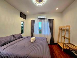 a bedroom with a bed with a ladder and a window at The Atlas hostel Muang Thong Thani in Thung Si Kan
