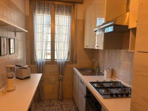 a small kitchen with a stove and a sink at GuestHouse Modena Buon Pastore in Modena