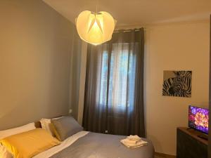a bedroom with a bed and a window with a television at GuestHouse Modena Buon Pastore in Modena