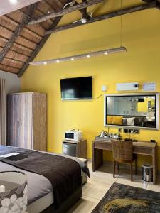 a bedroom with a bed and a desk and a tv at Highveld Splendour Boutique Bed and Breakfast in Ermelo
