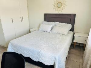 a bedroom with a large bed with white sheets at Valley Escape in Cape Town