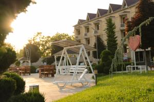 a pavilion with tables and chairs in front of a building at Gabala Yeddi Gozel Hotel in Gabala