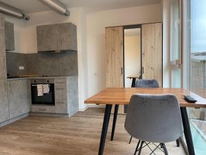 a kitchen and dining room with a wooden table and chairs at Apartmenthaus MK Immobilien in Stuttgart