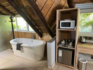 a bathroom with a bath tub and a microwave at Highveld Splendour Boutique Bed and Breakfast in Ermelo +50 photos