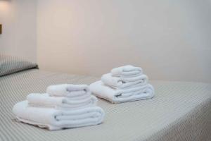 three towels stacked on top of a bed at Villaggio Turistico Priori Malcesine in Malcesine +147 photos