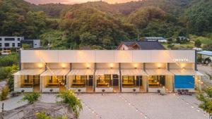 an aerial view of a building with a mountain in the background at GaPyeong Yeoldudal Spapension&Camping in Gapyeong