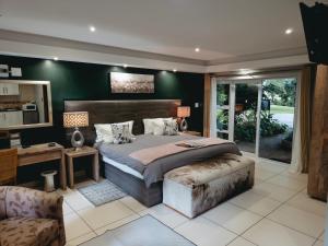 a bedroom with a large bed and a desk at Highveld Splendour Boutique Bed and Breakfast in Ermelo