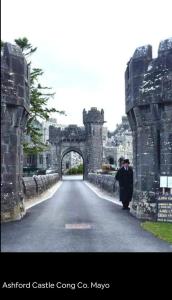 an old stone bridge with a man walking down a road at This is the Place in Ballinrobe +6 photos