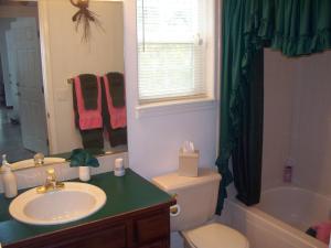 y baño con lavabo, aseo y bañera. en River Cove Elegant Waterfront Bed & Breakfast, en Post Falls