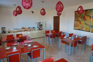 a restaurant with red tables and chairs and a counter at Amir Hotel in Karakol