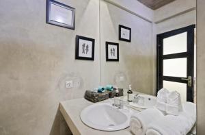 a bathroom with a white sink and a mirror at Modern Apartment with Shared Pool - By the Beach in Seminyak