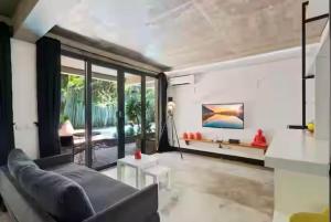 a living room with a couch and a large window at Modern Apartment with Shared Pool - By the Beach in Seminyak