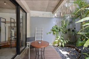 a room with a table and some plants at Modern Apartment with Shared Pool - By the Beach in Seminyak