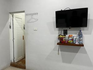 a flat screen tv hanging on a wall at Sapo Guest House in Berastagi +21 photos