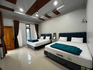 a bedroom with two beds in a room at Sapo Guest House in Berastagi