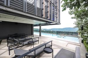 an outdoor patio with tables and a swimming pool at Mossaz Suites by Mana Mana in Petaling Jaya