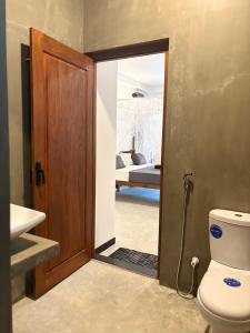 a bathroom with a toilet and a bedroom with a bed at Minuda Villa in Kamburugamuwa +93 photos
