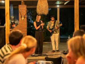 a man and a woman on a stage playing music at Rupas Hotel in Arugam Bay