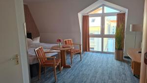 a room with a table and chairs and a bed at Hotel Prignitz in Wittenberge