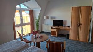 a hotel room with a bed and a desk with a television at Hotel Prignitz in Wittenberge