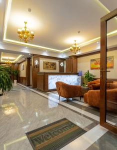 a lobby with couches and a podium in a building at Zarafshon Garden Hotel in Bukhara