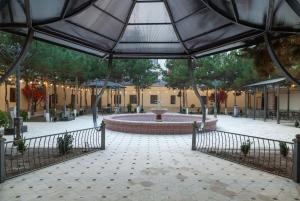 a courtyard with a fountain in the middle of a building at Zarafshon Garden Hotel in Bukhara