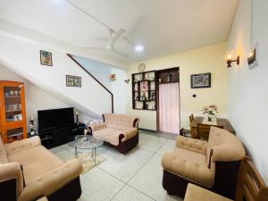 a living room with two chairs and a tv at Anu Home Stay in Ahangama