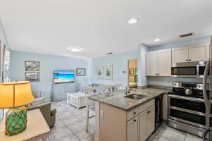 a kitchen and living room with a counter top at Le Monaco - 1 BR Romantic Condo! Getaway Steps from 5th Ave S Stylish Coastal Retreat with King Bed Beach Access and Prime Location, Near Dining Shopping and Sunset Views! in Naples +5 photos