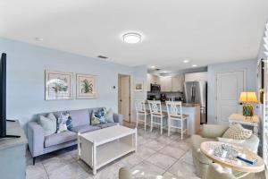 a living room with a couch and a table at Le Monaco - 1 BR Romantic Condo! Getaway Steps from 5th Ave S Stylish Coastal Retreat with King Bed Beach Access and Prime Location, Near Dining Shopping and Sunset Views! in Naples