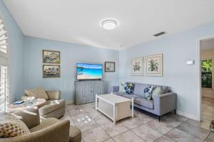 a living room with a couch and a table at Le Monaco - 1 BR Romantic Condo! Getaway Steps from 5th Ave S Stylish Coastal Retreat with King Bed Beach Access and Prime Location, Near Dining Shopping and Sunset Views! in Naples