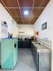 a kitchen with a blue refrigerator and a counter at Anu Home Stay in Ahangama