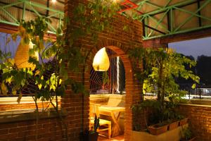 eine gemauerte Terrasse mit Tisch und Stuhl in der Unterkunft Luna Leaf in Kandy