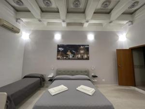 ein Schlafzimmer mit zwei Betten und einem Gemälde an der Wand in der Unterkunft Hotel Gorizia in Catania