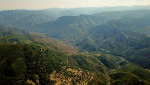 an aerial view of a mountain valley with trees at Penev guest house in Glavatartsi