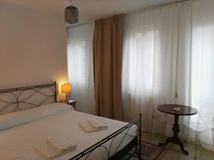 sypialnia z łóżkiem, stołem i oknem w obiekcie Butterfly Guest House w Wenecji