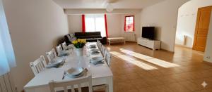 a white table and chairs in a living room at Villa au calme, piscine couverte chauffée 365j in Thiberville
