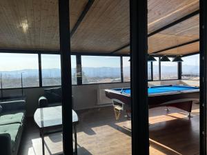 a house with a pool table in a room with windows at Terrace Eniseli in Eniseli