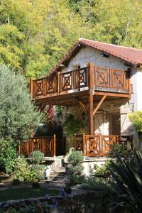 a house with a wooden bridge over a yard at Moulin des Faurilloux in La Chapelle-Faucher
