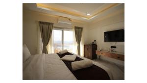 a bedroom with a bed and a large window at The Mansion Resort And Spa in Panchgani
