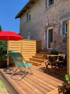 a deck with a table and chairs and an umbrella at La Bulle d Avenir in Corcieux