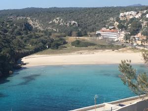 a view of a beach next to a body of water at Private beautiful house - ( nice swimming Pool) in Cala en Porter