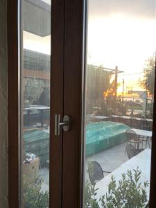 eine Glasschiebetür mit Blick auf einen Swimmingpool in der Unterkunft El Boutique Hotel in Tyros