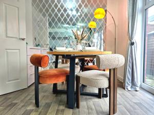 a dining room table with two chairs and a tableweredotentotent at The Charm Luxury House - 8mins to NEC, Birmingham Airport in Marston Green