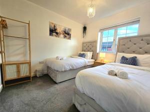 a bedroom with two beds and a window at The Charm Luxury House - 8mins to NEC, Birmingham Airport in Marston Green +41 photos