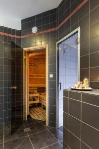 a kitchen with black tiled walls and a open door at Hotel Rusava 2 depandance in Rusava +37 photos