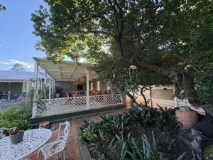 a house with a table and chairs in front of it at Silver Linings Cottage in Parys