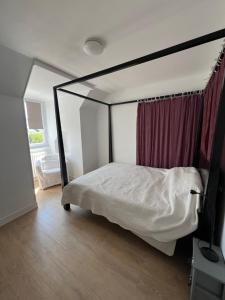 a bedroom with a canopy bed and a window at Au Vingt Neuf in Loches
